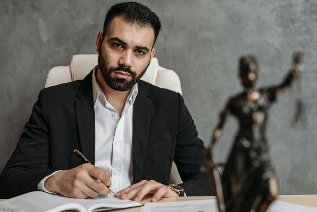 pexels photo 8112114 8112114 A serious lawyer in a black suit working diligently at his office desk.