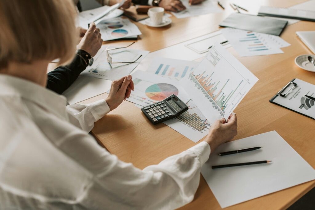 pexels photo 7433836 7433836 Business team analyzing financial data and graphs during a meeting to strategize growth.