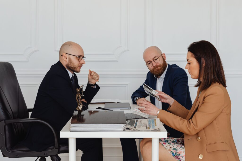 pexels photo 7876092 7876092 A group of professionals discussing and reviewing documents in an office setting.